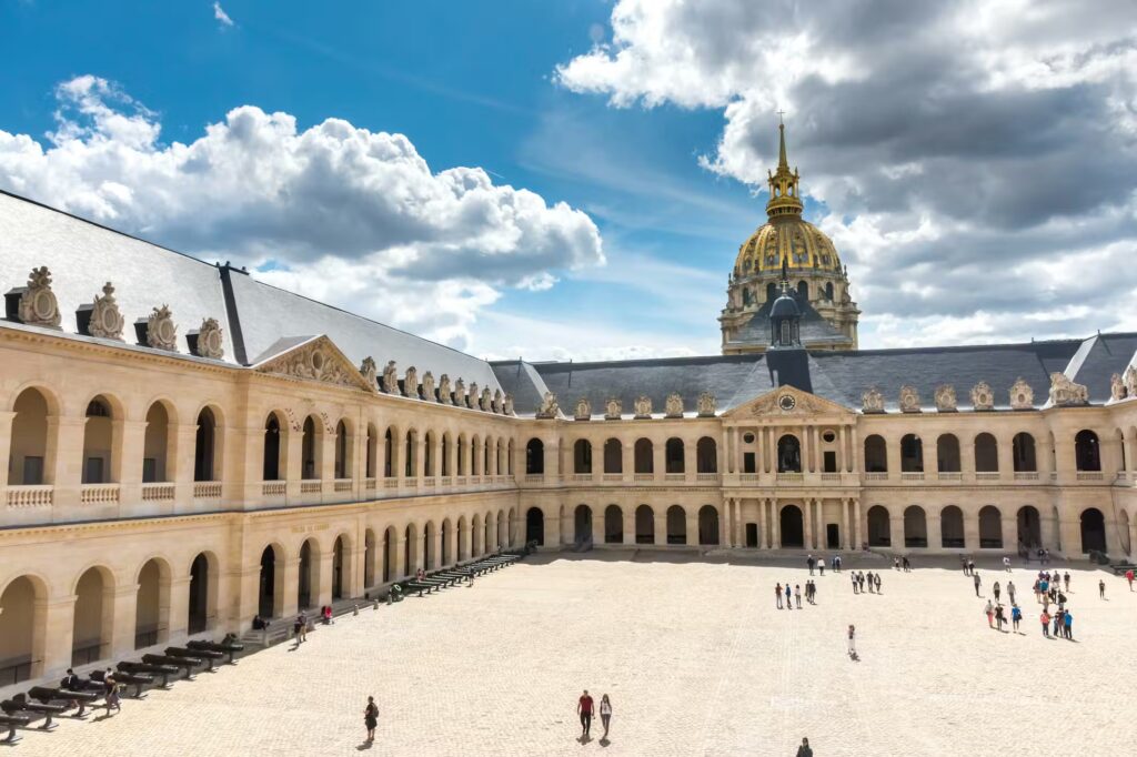 Courtyard view of Les Invalides in Paris, featuring its iconic golden dome and architecture.